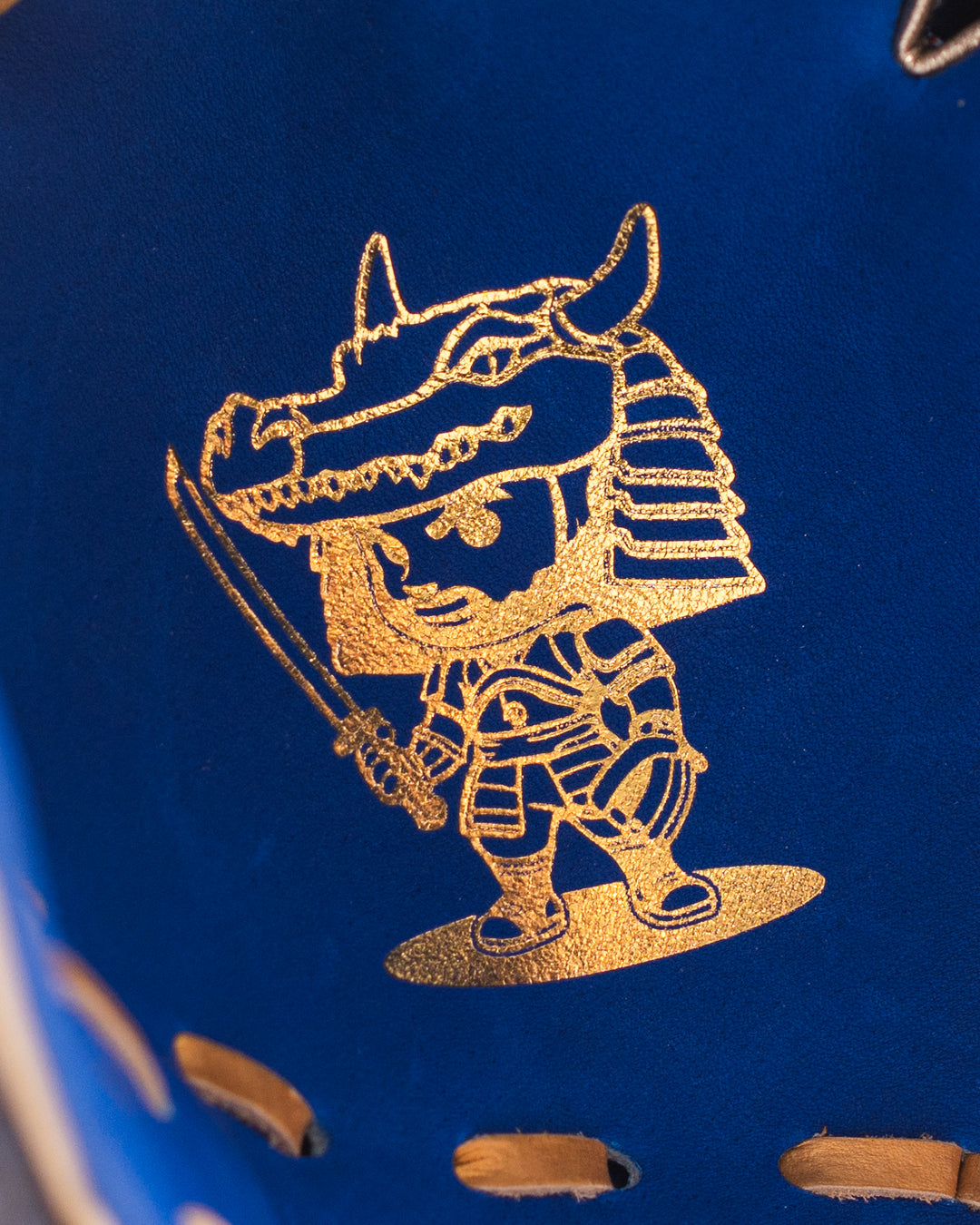 Gold embossed design of a warrior on a blue background