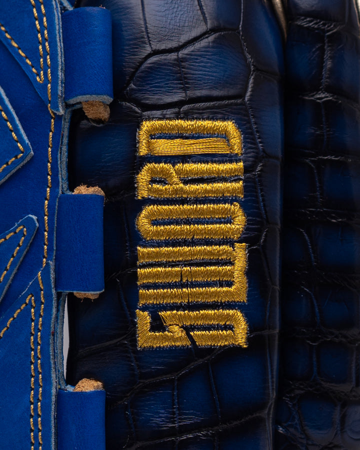 Close-up of a blue glove with gold 'G-Form' branding.